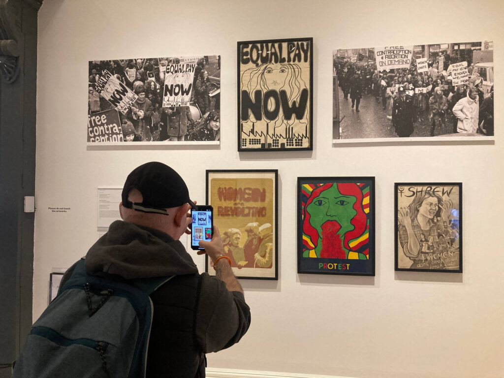 Alan taking a photograph of artwork in the Women in Revolt exhibition.