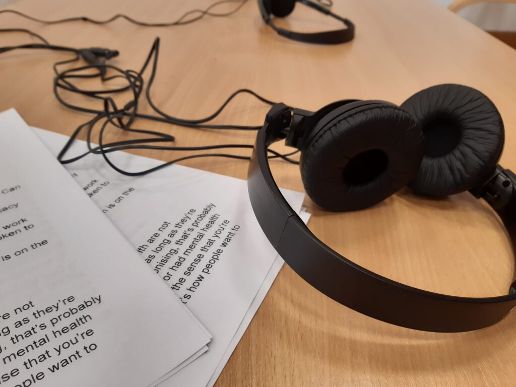 Listening station for Can you hear us? sound recordings made at the People's Conference. Shows headphones and transcripts lying on a table.
