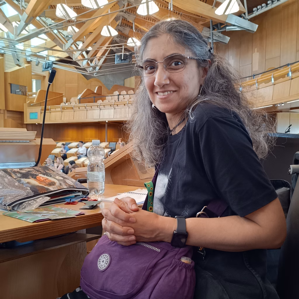 Lauren Stonebanks, member of the Out of Sight Out of Mind planning group, smiling towards the camera, pictured in the Scottish Parliament.