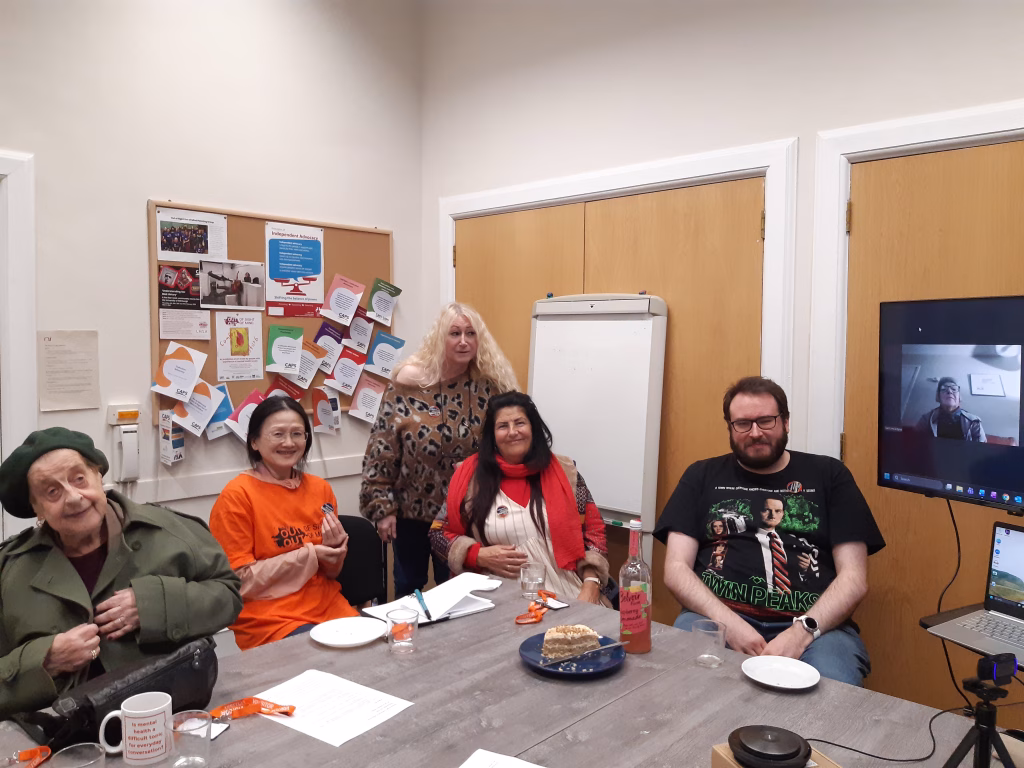 Collective Advocacy participants - five people seated around a table with one further person on a screen.